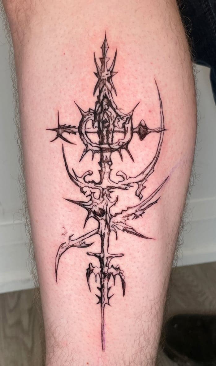 Cybersigilism blade with crescent and spikes in fine blackwork on a shin