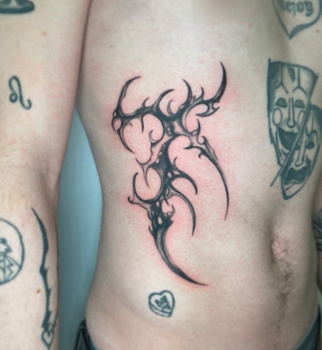 Spiked cybersigilism heart in tapering black strokes on the ribs