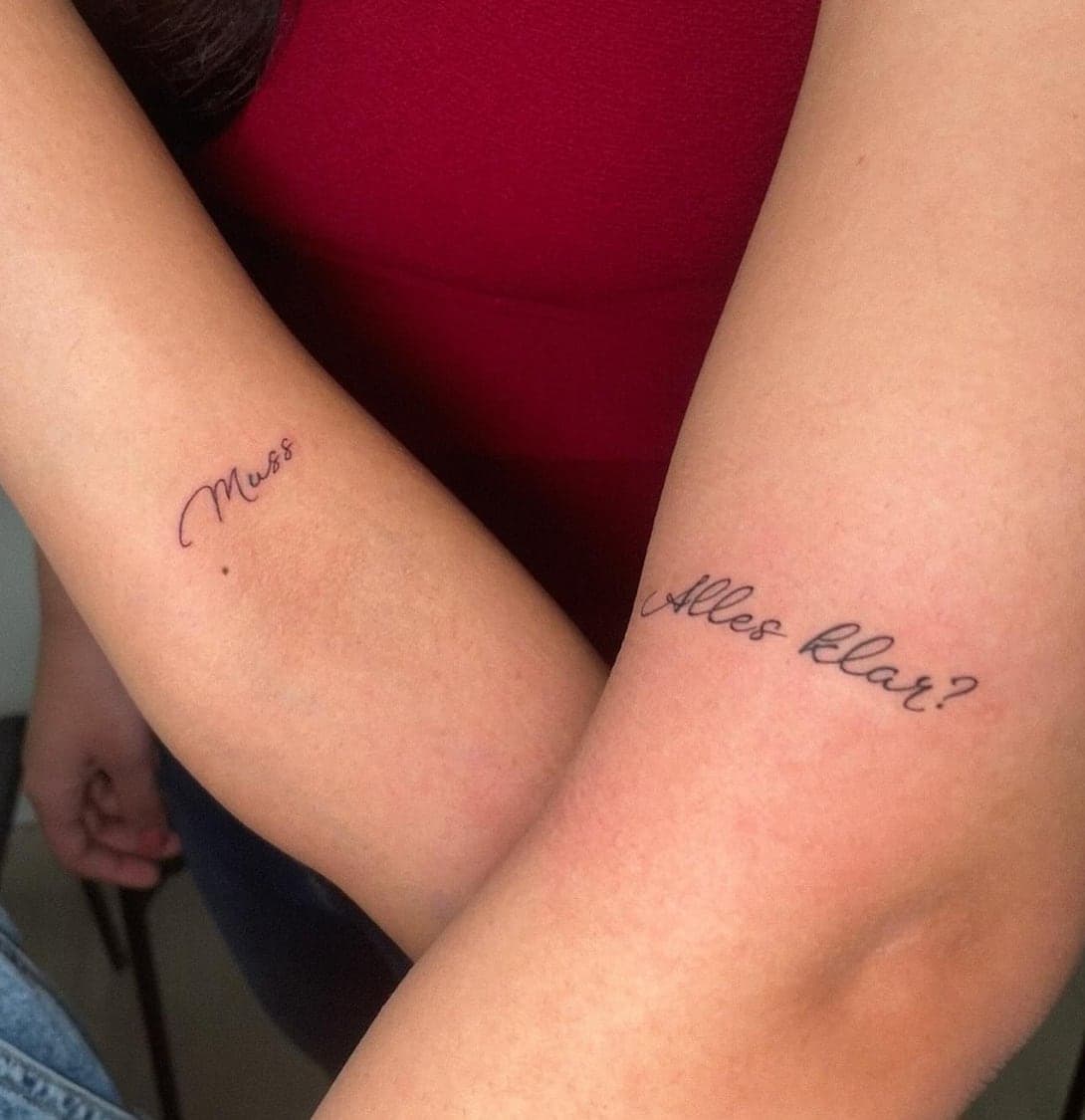 Matching fine cursive script pieces on two arms side by side