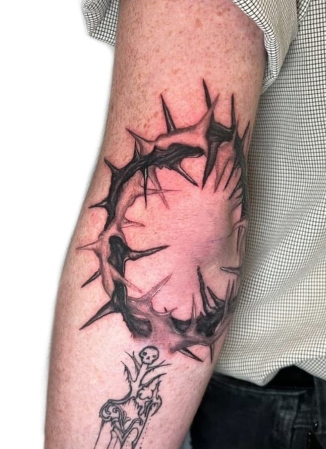 Black thorn crown circling an elbow with sharp tapering spikes